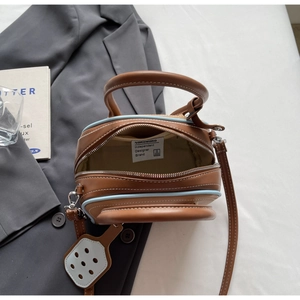 Detail view of the designer brand label and inner lining of a stylish two-tone handbag