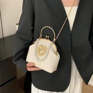 Baroque shell crossbody bag with pearl handle and golden heart relief buckle detail