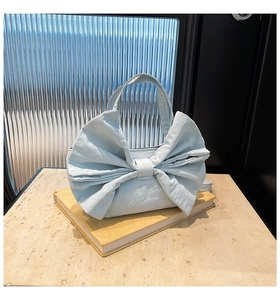 Vue détaillée du sac cabas en tissu bleu clair avec un grand nœud décoratif sur le devant