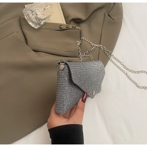 Detailed view of silver woven textured mini envelope bag with slim metal chain strap