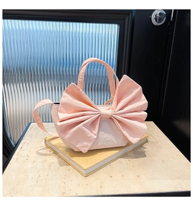 Détail du sac cabas rose en toile avec grand nœud et finition à texture plissée élégante