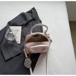 Detail view of pink and white contrast bowling bag with inner lining and brand tag