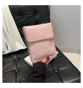 Detail of light pink mini chain bag with metallic woven edge and flap closure