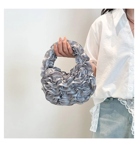 Detail of silver pleated ruffled crescent handbag with glossy silk texture for women