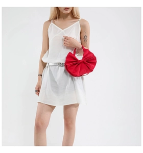 Mannequin portant un grand sac cabas satiné rouge en forme de nœud élégant