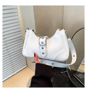Détail d'un sac demi-lune blanc avec des rivets argentés et similicuir texturé