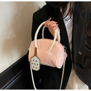 Detail of pink and white macaron style bowling bag with a paddle-shaped cutout charm