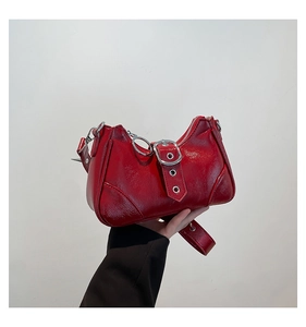 Detail der roten Lackleder Y2K Schultertasche mit Metallschnalle und Silberring-Anhänger