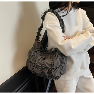 Detailed view of charcoal grey pleated cloud bag showing glossy textured fabric