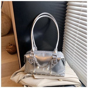 Details der silbernen Metallic-Handtasche mit Perlenkette und silbernen Nietendetails
