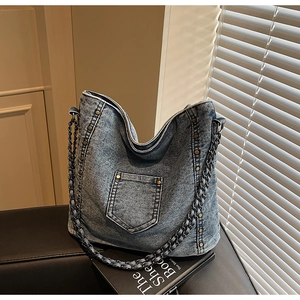 Λεπτομέρεια vintage τσάντας denim με ρετρό μεταλλικά πριτσίνια και υφαντό ιμάντα αλυσίδας