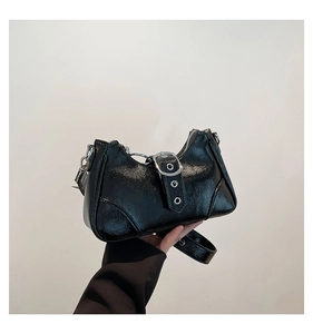 Detail der schwarzen Lackleder-Baguette-Tasche mit Silberschnalle und Glanzeffekt