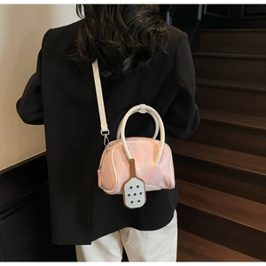 Detailed back view of a pink and white macaron bowling bag worn with a black blazer