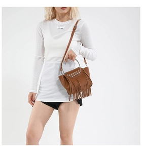 Close-up of brown fringe handbag with silver studs and metal ring handle details