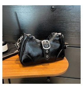 Detailaufnahme der schwarzen Glanz-Tasche mit silbernen Nieten und Metallschnalle