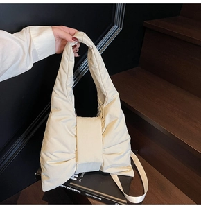 Detail view of cream puffy tote bag with bow design and quilted nylon texture