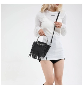 Dettaglio della borsa in pelle nera con borchie argentate e lunghe frange nappe