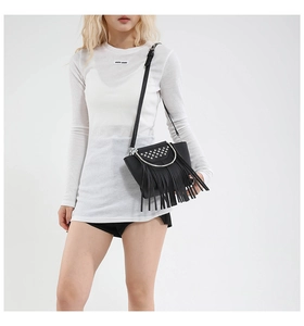 Close-up of black lychee grain leather shell bag featuring silver studs and long tassels