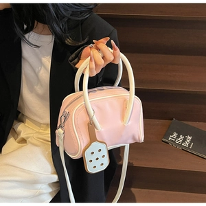 Detailed close-up of pink and white macaron style crossbody bag with leather texture