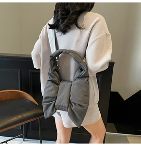 Detail view of large dark grey nylon bow shoulder bag showing soft texture and padded design