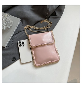 Pink crossbody phone bag featuring gold chain trim and metallic strap on a grey blazer