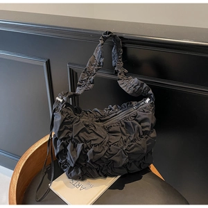 Detailaufnahme der schwarzen Falten-Tasche mit Wolken-Textur und silbernem Metallreißverschluss