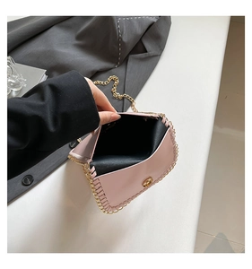 Detail of pink crossbody bag with gold chain trim and secure magnetic clasp
