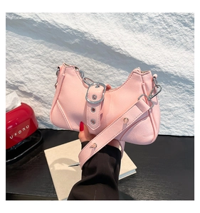 Gros plan du sac à main rose en cuir grainé avec des rivets et des finitions métalliques