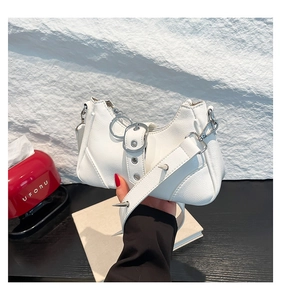 Détail du sac de moto en cuir blanc avec rivets argentés et boucle de décoration
