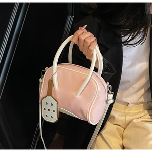 Detail of pink and white bowling bag with detachable strap shown on a model