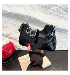Détail du sac en cuir verni noir avec rivets en métal argenté et boucles décoratives
