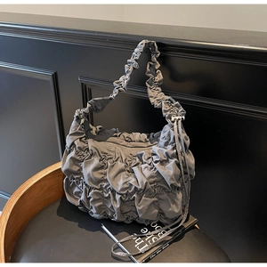 Detail of dark grey puffer cloud bag showing intricate pleated texture and drawstring