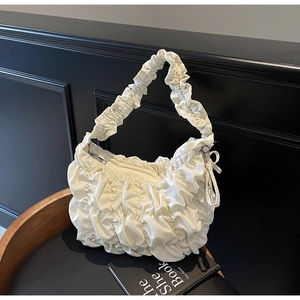 Detailansicht der cremefarbenen Dumpling-Bag mit plissierter Wolkenstruktur und Schleife