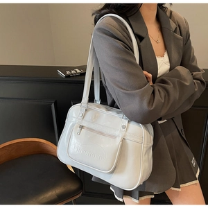 Vue détaillée du sac blanc brillant avec logo Noronoro et poche avant zippée