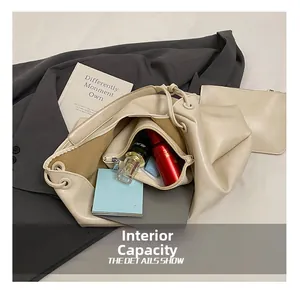 Detail view of large beige tote bag with inner pouch showing spacious storage capacity