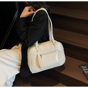 Détail du sac à dos en similicuir crème avec gaufrage de lettres et poche latérale zippée