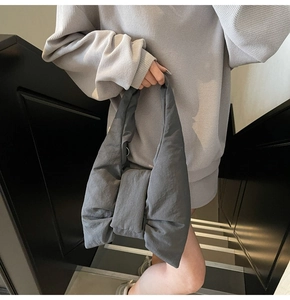 Detail view of the oversized dark grey bow-shaped nylon tote bag on a model shoulder