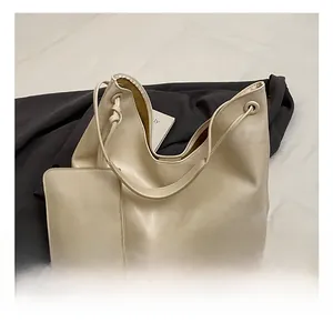 Detail of cream leather tote bag set including a large shoulder bag and small zipper pouch