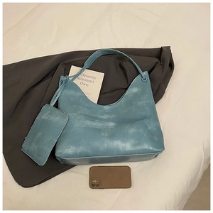 Detail of the vintage washed blue tote bag set with cylindrical handles on a clean background
