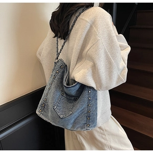Close-up of retro denim tote bag with silver studs and metal chain shoulder strap
