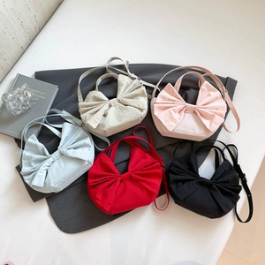 Sacs cabas en toile à nœud papillon en cinq couleurs présentés sur fond sombre