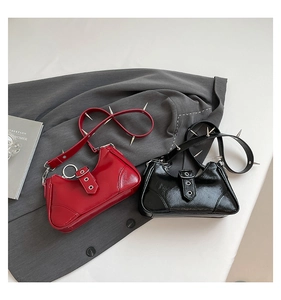 Détail de sacs sous le bras punk en rouge et noir, cuir verni avec des clous argentés