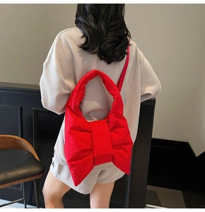 Close-up of a large red bow-shaped padded shoulder bag made of waterproof nylon fabric