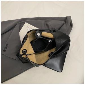 Detail of black tote bag featuring camel suede lining and a removable zipper pouch