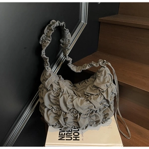 Detail der grauen Puff-Tasche mit Nylon-Textur und eleganten Wolkenfalten-Akzenten