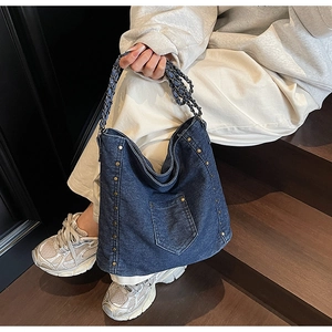 Λεπτομέρεια vintage μπλε τσάντα denim με χάλκινα πριτσίνια και λουράκι αλυσίδας