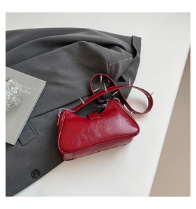 Detailaufnahme der roten Lackledertasche mit silbernen Punk-Nieten und Spiegeleffekt