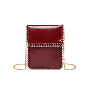 Vertical wine red leather phone crossbody bag with gold chain trim on white background