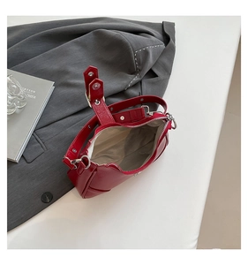Details der roten glänzenden Ledertasche mit Reißverschluss und cremefarbenem Futter