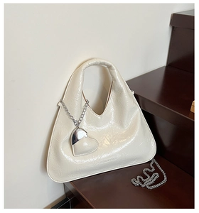 Detail of cream pleated leather bag with heart pendant and Fashion & Bags embossment